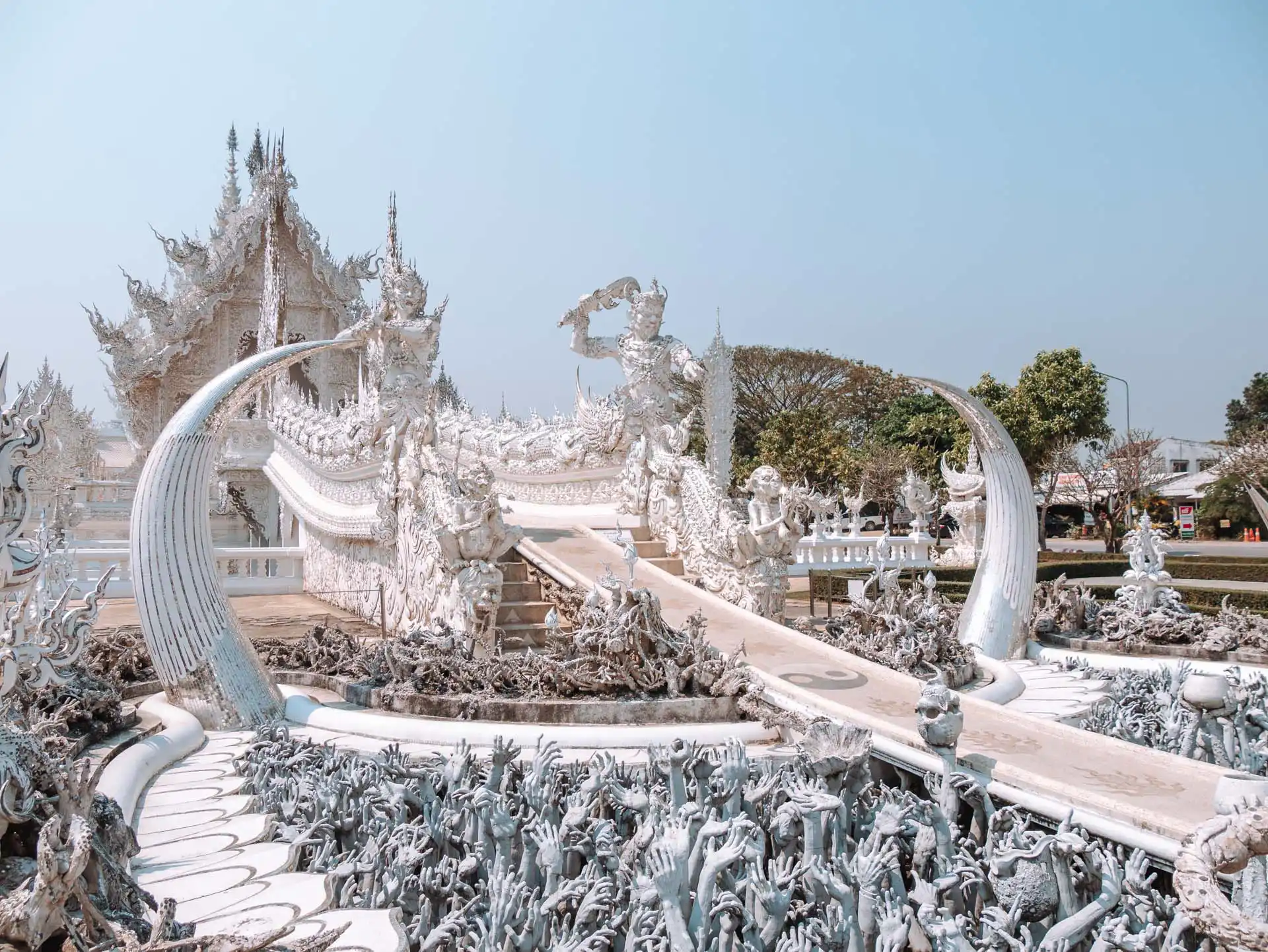 Hände und Hölle - der weiße Tempel in Chiang Rai in Thailand